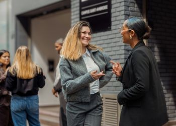 Dates de rentrée pour l'année 2025/2026 Deux jeunes femmes devant une écoles de tourisme discutent ensemble